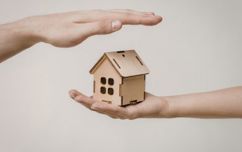 Hands With A Wooden House